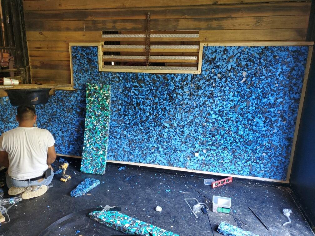 Padded wall being installed, showing the underpad, an ideal solution for a comfortable horse stall