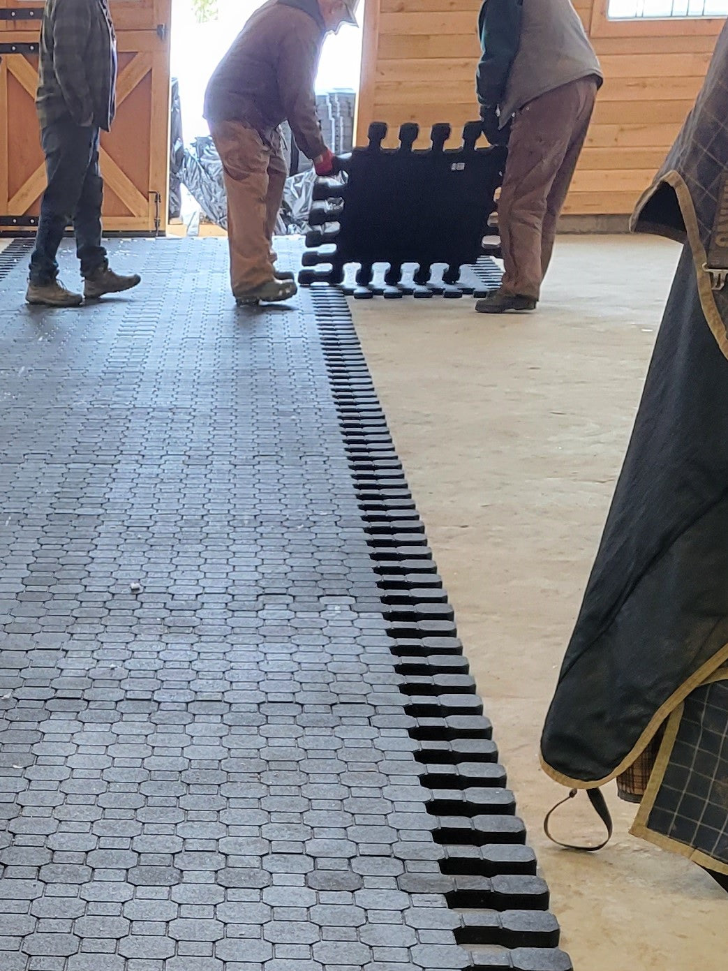 Rubber interlock flooring being put together, an easy solution for comfortable barn flooring